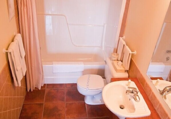 Un baño con bañera, inodoro y lavabo.