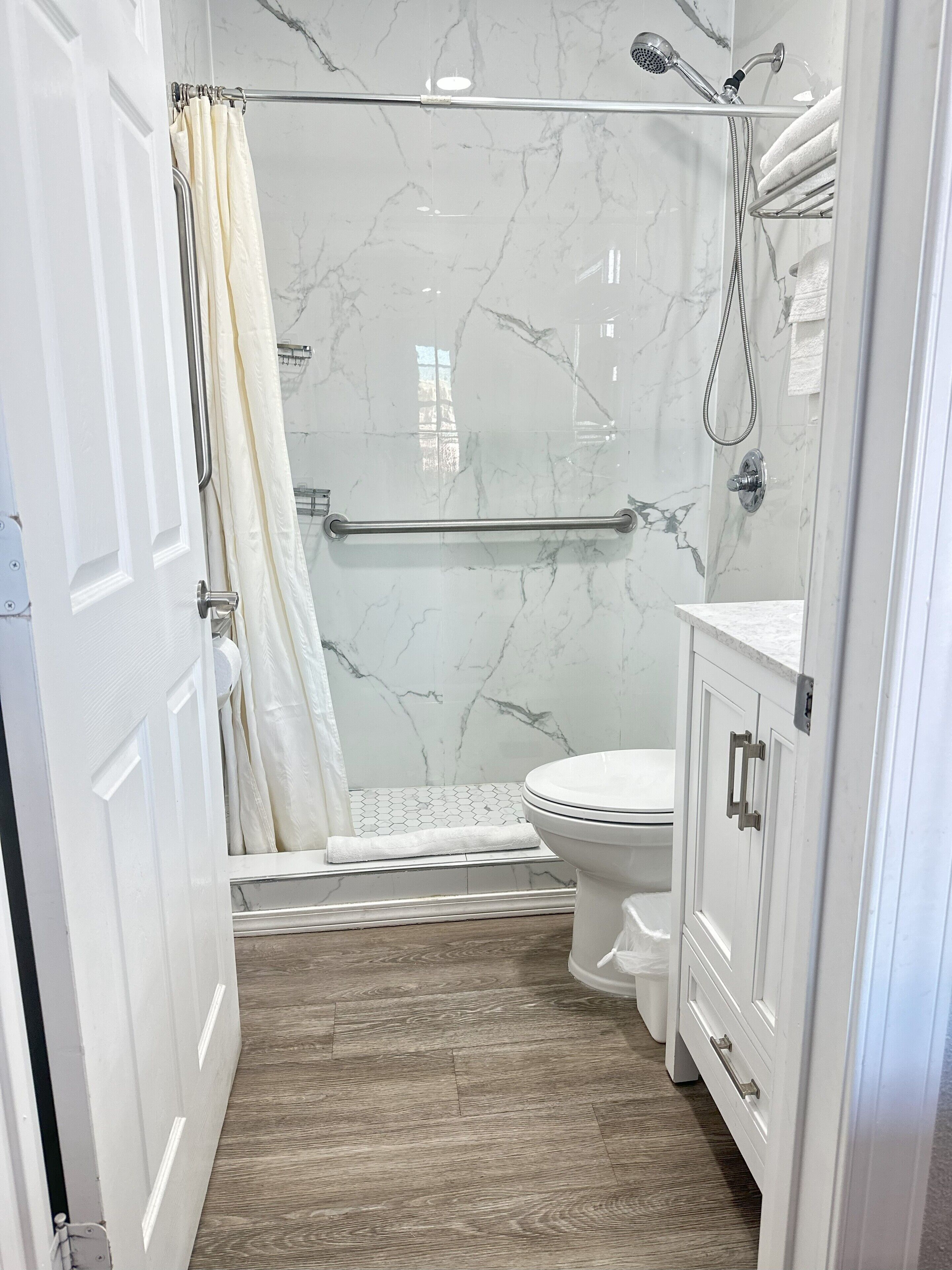 Une salle de bain avec douche, toilettes et lavabo.