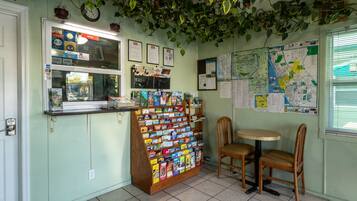 A small office with a bulletin board, a display of postcards, and a map on the wall.