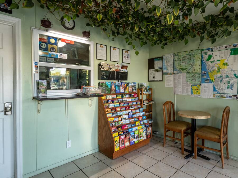 A small office with a bulletin board, a display of postcards, and a map on the wall.