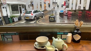 A table with tea set and a view of a street outside. - King William IV (Totnes)