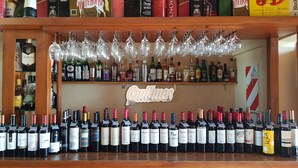Zona de bar con una variedad de botellas de licores y copas de vino exhibidas en estanterías.