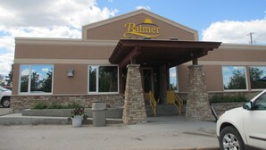 Un bâtiment sur lequel on peut lire l’inscription « Palmer », et dont l’entrée est couverte et soutenue par des piliers en pierre.