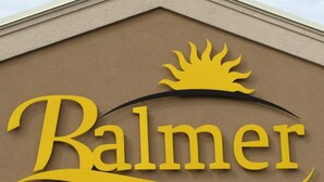 Une enseigne d’hôtel portant le nom « Balmer Hotel » et un motif représentant un soleil au-dessus du texte.