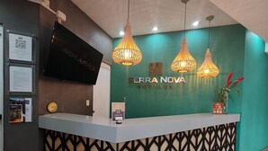 Uma receção nos SERRA NOVA HOTELS com um design moderno, incluindo um sinal de check-in/out, um ecrã digital e iluminação decorativa.