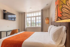 أغطية فراش متميزة وميني بار وخزنة داخل الغرفة ومكتب