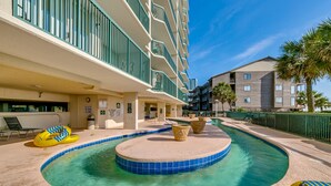 A hotel pool area with a circular hot tub, lounge chairs, and a lifeguard stand. - Ashworth by Condo-World (North Myrtle Beach)