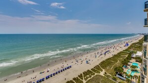 A beach with a swimming pool and a building with balconies. - Ashworth by Condo-World (North Myrtle Beach)