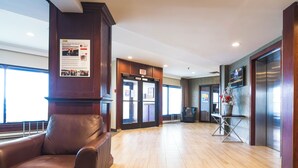 Eine großzügige Lobby mit Ledersessel, Rezeption und Aufzug.