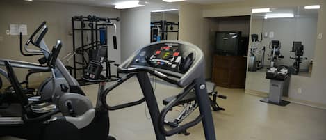 A gym with treadmills, elliptical machines, and weightlifting equipment.