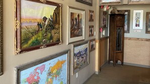 A gallery wall with various framed artworks and a world map. - Rawlins Lodge (Rawlins)
