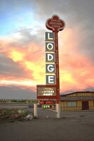 Señal para Rawlins Western Lodge, con un letrero de neón que anuncia MS Ail y Col RV.