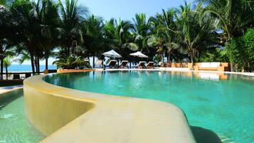 Alberca al aire libre, sombrillas en la alberca y camastros