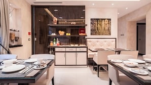 A modern hotel dining area with a central buffet, seating arrangements, and a large painting on the wall. - Maison Candia Luxury House (Rome)