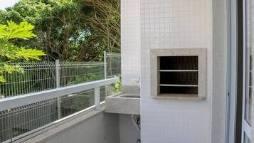 Une salle de bain avec un lavabo, une petite fenêtre et un mur recouvert de carreaux.