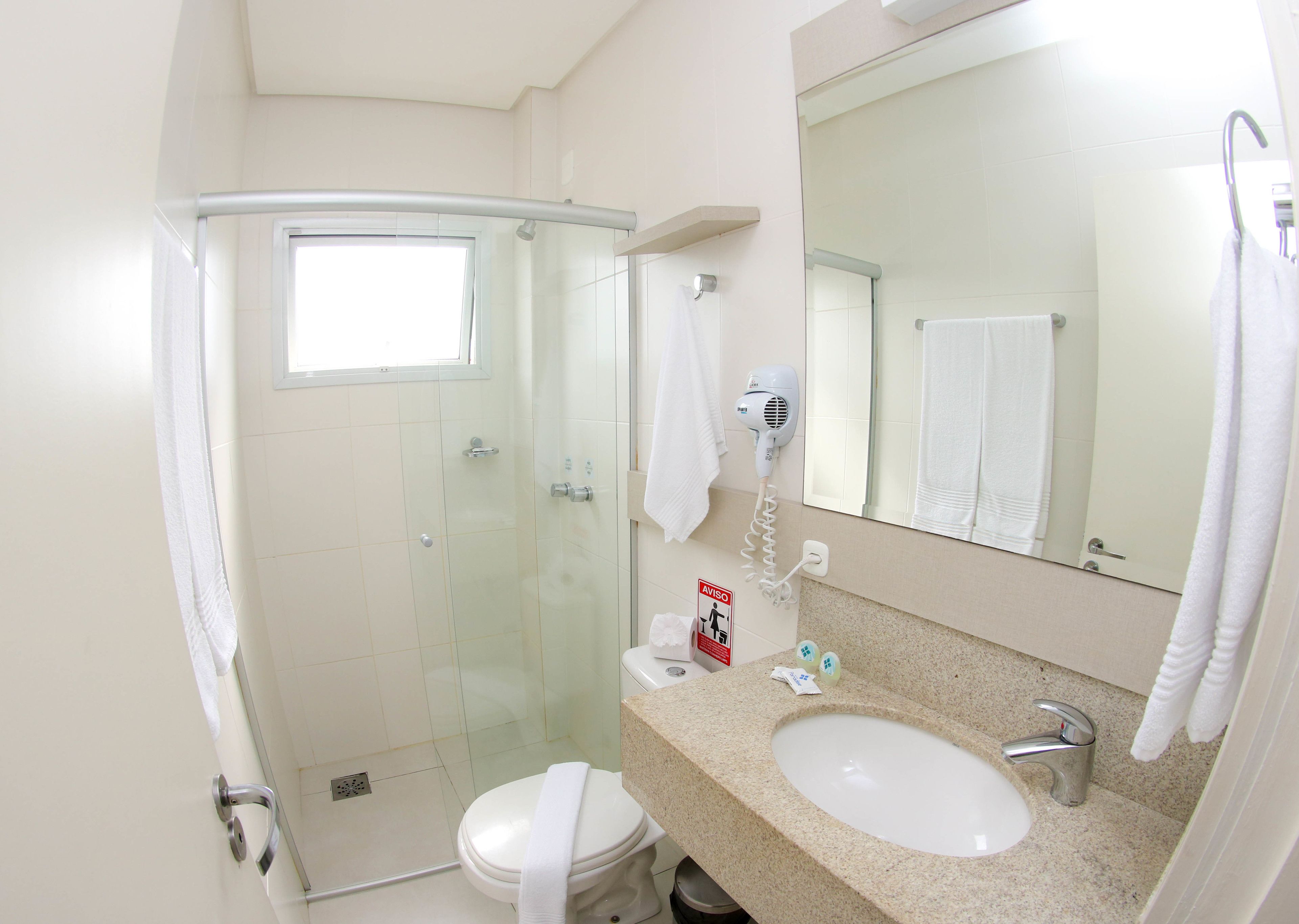 A modern bathroom with a glass shower enclosure, a sink with a vanity, and a large mirror.
