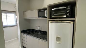 Een kleine keuken met een magnetron, broodrooster en koelkast.