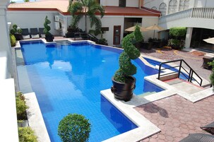 Una piscina al aire libre, sombrillas