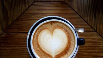 Una taza de café con un dibujo de corazón en la espuma sobre una mesa de madera.
