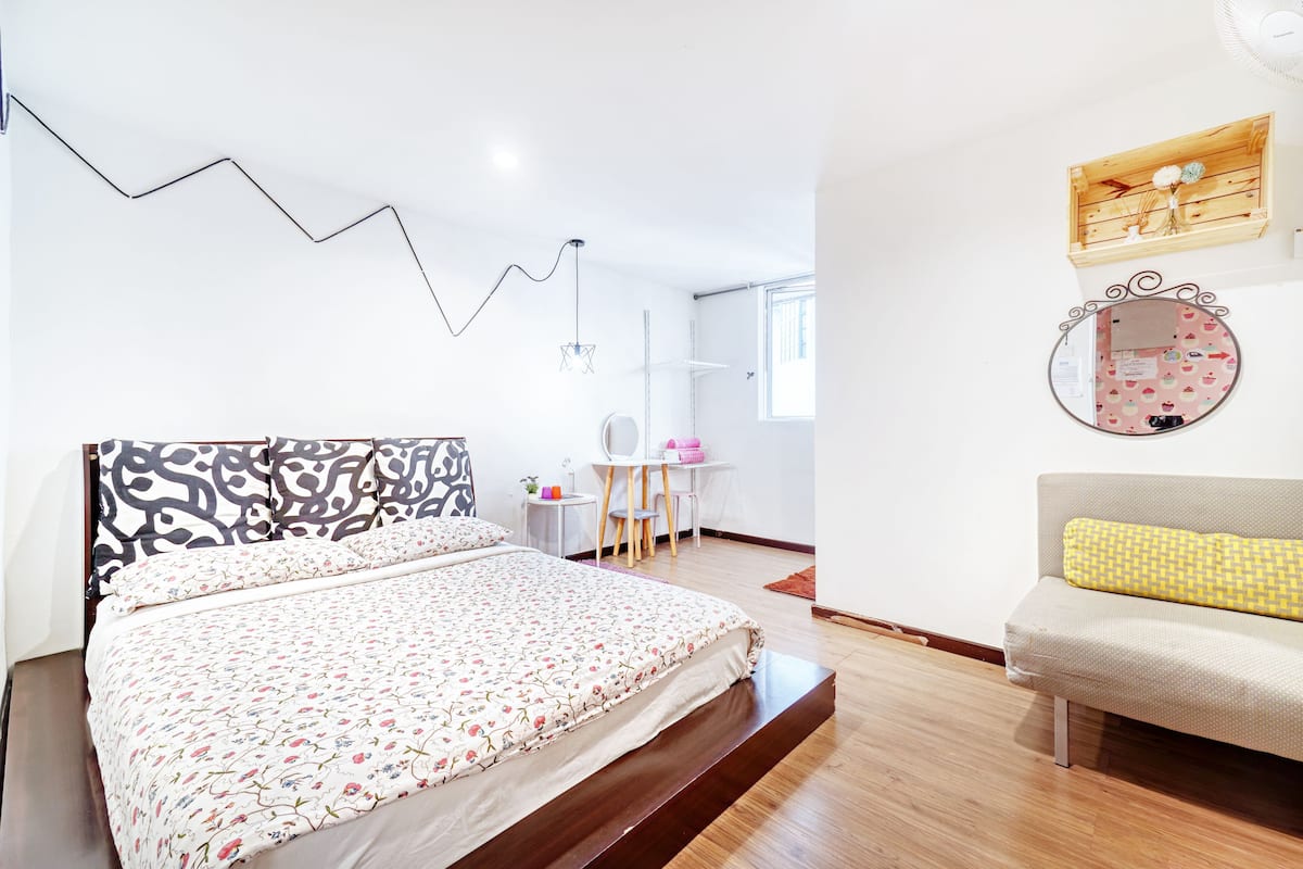A modern bedroom with a large bed, a desk, and a chair.