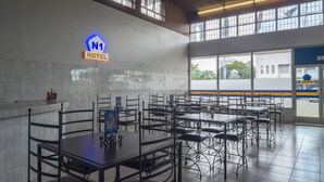 A spacious hotel dining area with multiple tables and chairs, a visible N1 Hotel sign, and large windows offering a view of the outside. - The N1 Hotel Bulawayo (Bulawayo)