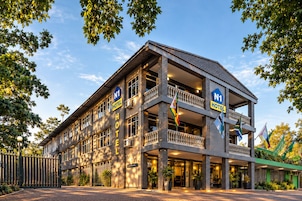 Un hotel con recepción, varios balcones y banderas.