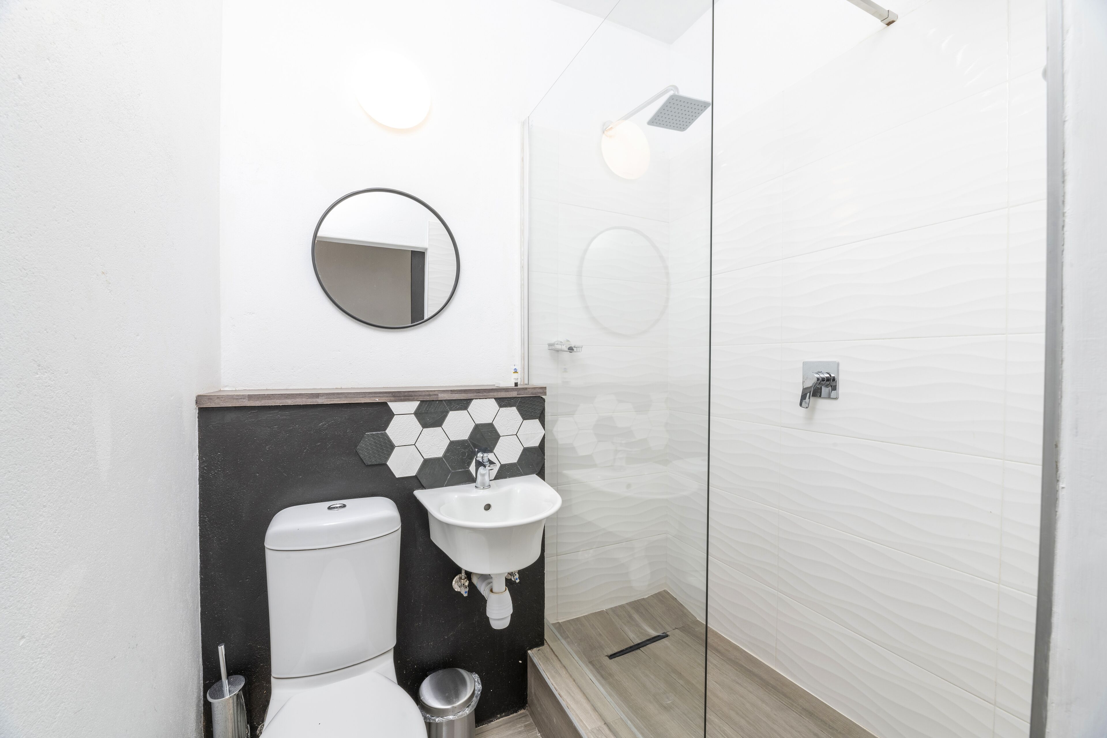 A modern bathroom with a toilet, sink, and shower.