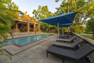 Piscina externa, guarda-sóis, espreguiçadeiras