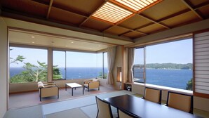 Una habitación moderna con ventanas amplias, techo de madera y vista al mar.