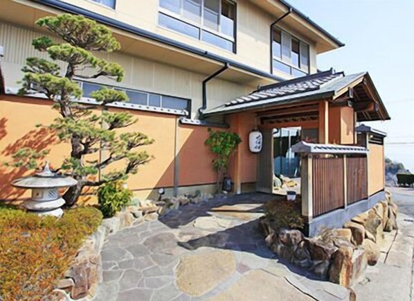 A traditional Japanese-style building with a stone pathway leading to the entrance.