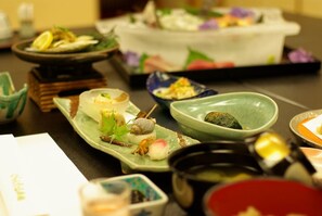 A variety of dishes on a table, including sushi and other small plates.