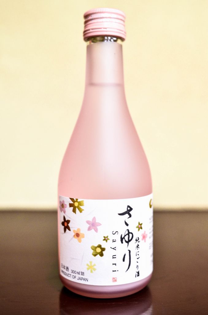 Eine Flasche mit einem Etikett, das japanische Schriftzeichen und florale Muster zeigt.