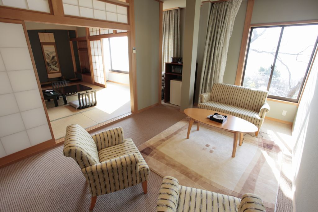 Een traditionele Japanse woonkamer met tatami vloerbedekking, een lage tafel en gestreepte banken.