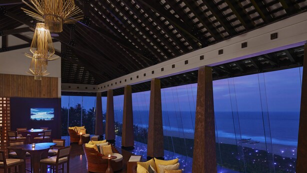 A modern lounge with a large TV, comfortable seating, and a view of the ocean. - Sentido Heritance Negombo (Negombo)