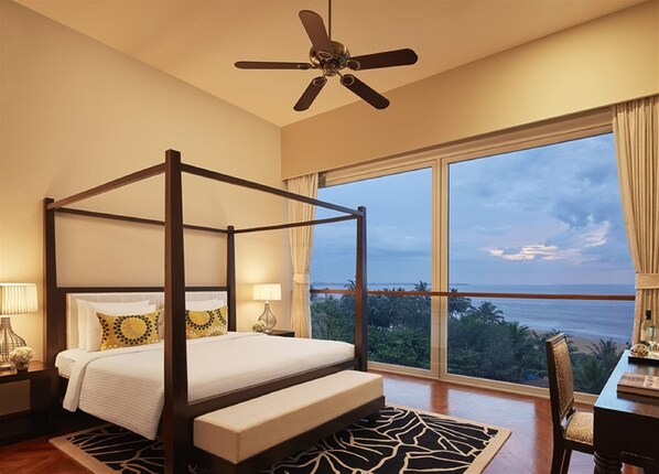 Una cama con dosel con vista al océano.