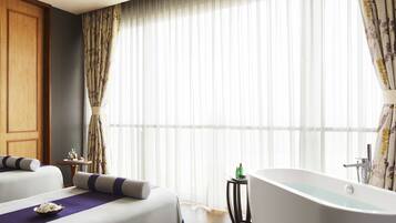 Relax in style with a bathtub and a comfortable bed.