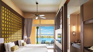 A hotel room with two beds, a TV, a ceiling fan, and a view of a pool and beach. - Sentido Heritance Negombo (Negombo)