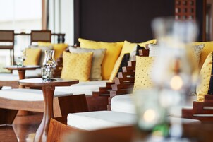 A seating area with wooden furniture and yellow cushions.