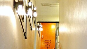 Un escalier dont les marches alternent entre le noir et le beige, avec des rampes de chaque côté et des numéros indiquant les niveaux des étages.