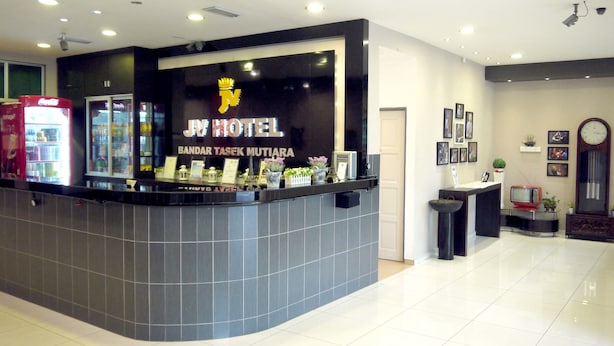 A hotel reception desk with a modern design, a clock, and framed pictures on the wall.
