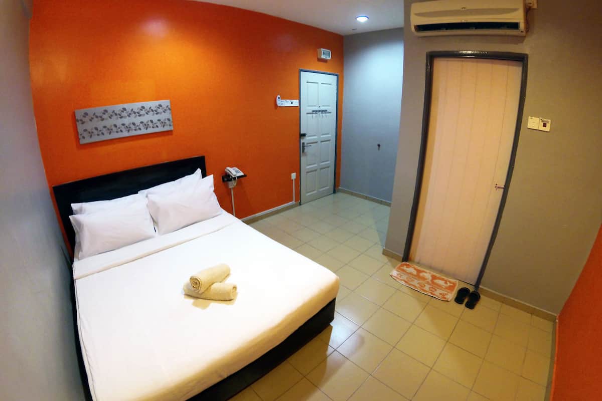 Ein Hotelzimmer mit Bett, Telefon, Klimaanlage und einer Tür.
