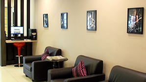 A lobby with black leather sofas, a reception desk, and framed artwork on the walls.