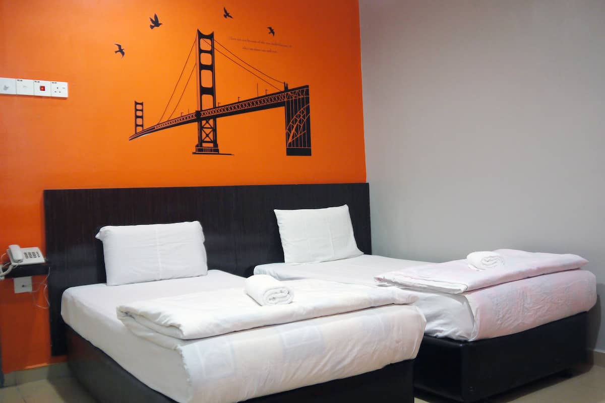 Ein Hotelzimmer mit zwei Betten, einem großen Wandbild der Golden Gate Bridge und einem Telefon auf dem Nachttisch.
