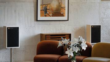 A modern living room with a sofa, a coffee table, and a framed artwork on the wall.