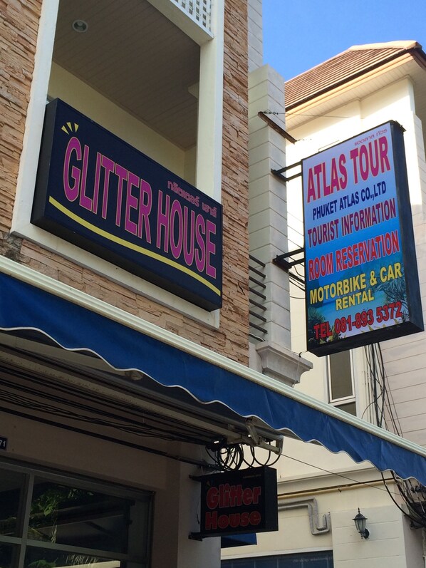 Rakennuksessa on kyltit, joissa lukee «Glitter House» ja «Atlas Tour».