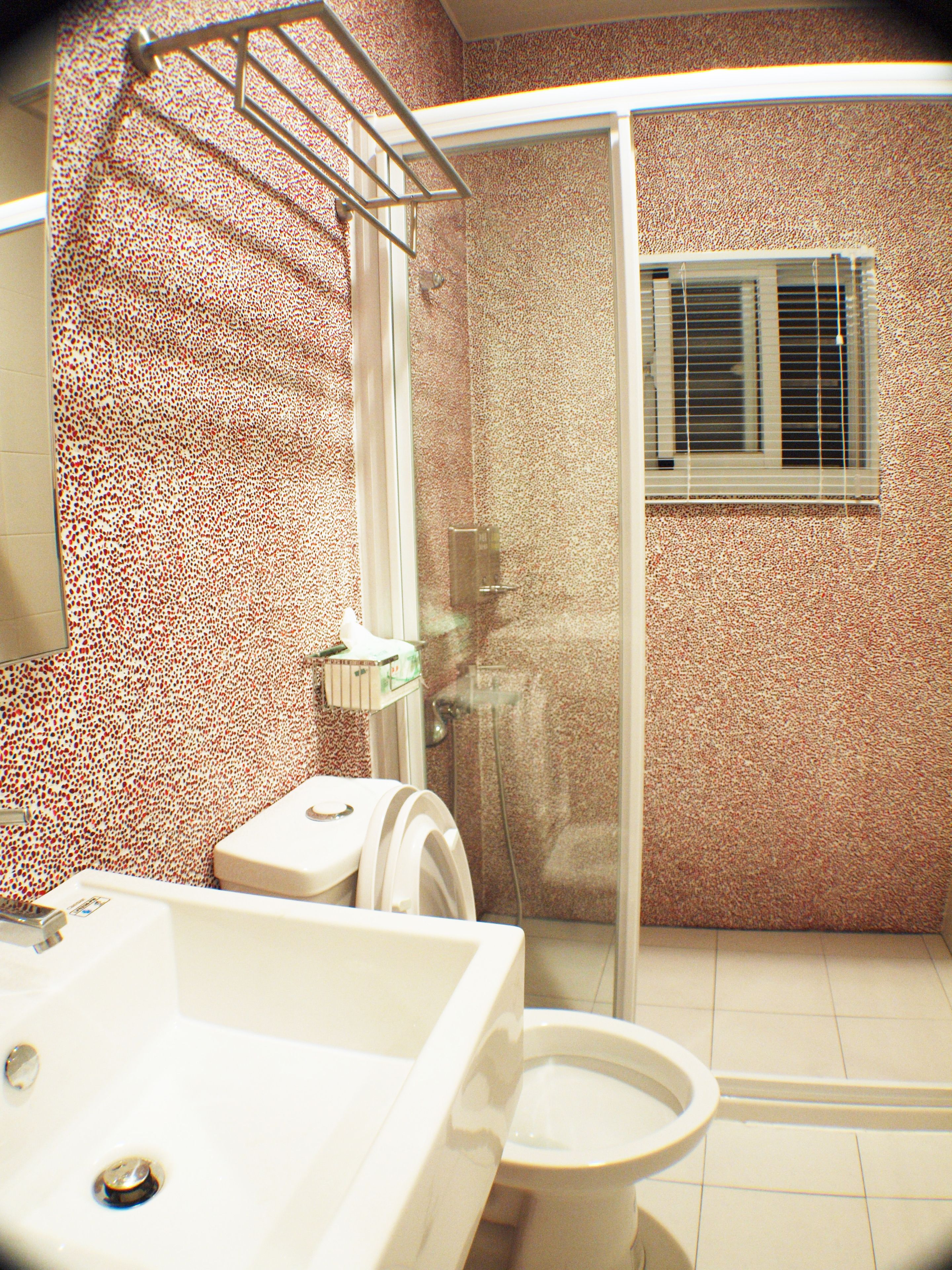 A bathroom with a shower, toilet, and sink.