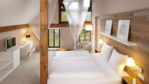 Une chambre à coucher avec un grand lit, un bureau avec un ordinateur, une chaise et un téléviseur.
