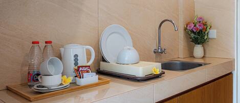 A kitchen counter with a coffee maker, a sink, and a vase with flowers.