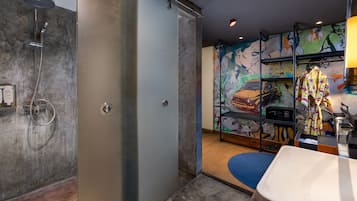 Un bagno moderno con doccia, lavandino e un murale colorato al muro.