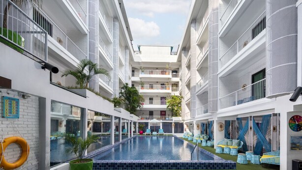 A modern hotel atrium with a central pool, multiple balconies, and outdoor seating areas. - Viva Dash Hotel Seminyak (Keroboken Kelod)
